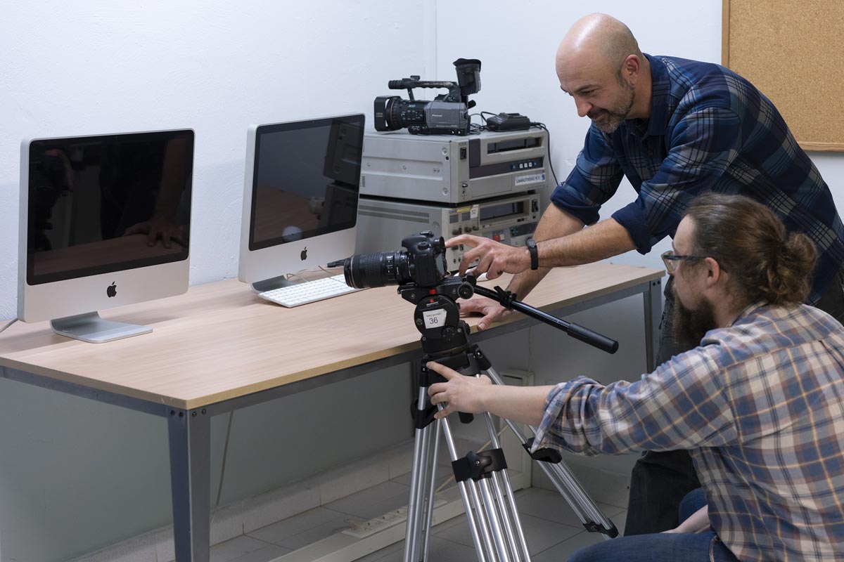 Dos personas visualizando el monitor de una cámara fotográfica.