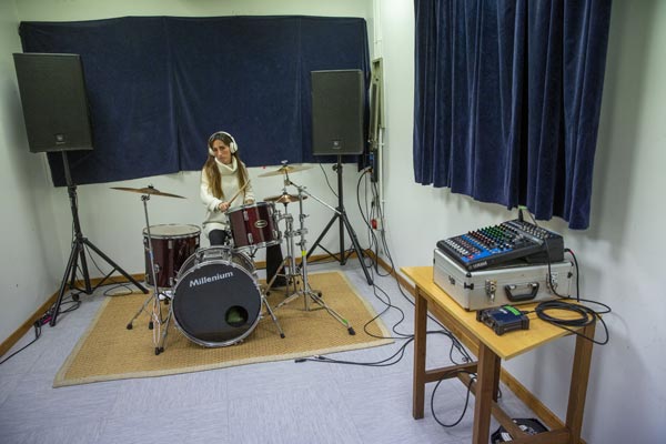 Mujer tocando la batería en el local de ensayo de Egia