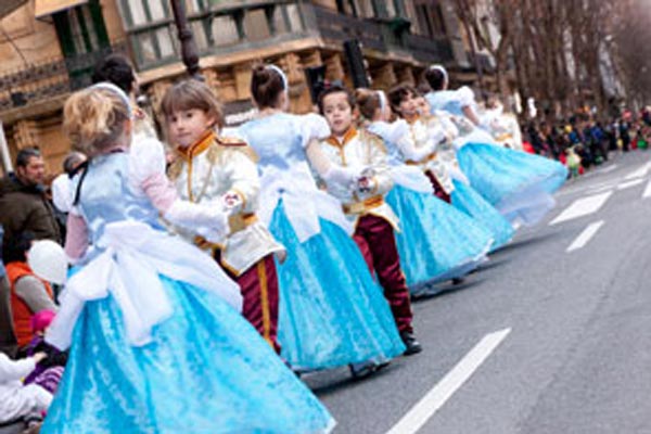Niños y niñas de la Comparsa Santa Bárbara desfilando por las calles de Donostia