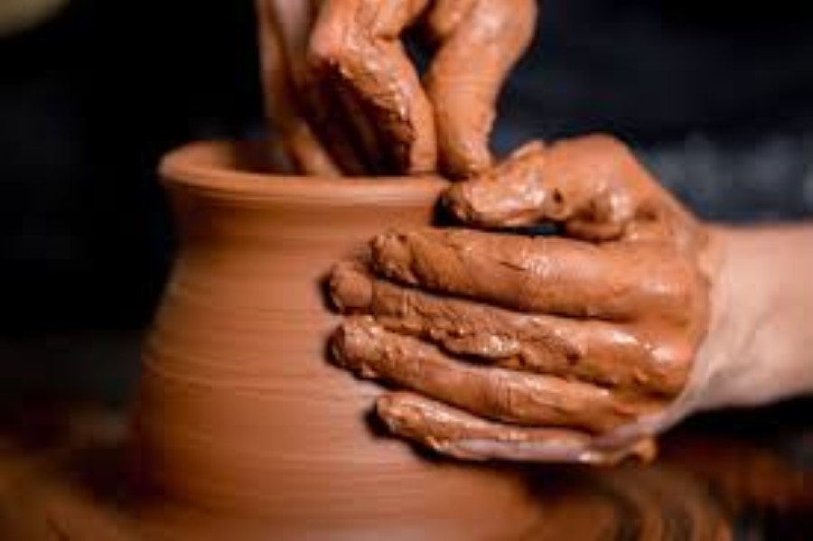 Dos manos realizando pieza cerámica en torno