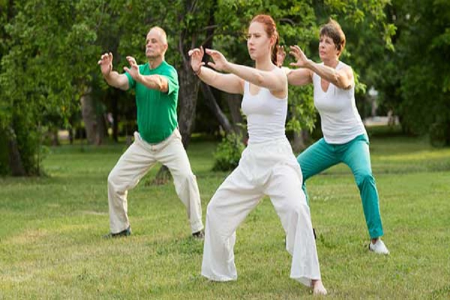 Tres personas realizando ejercicios de Tai Chi