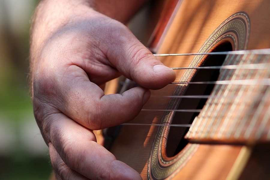 Pertsona gitarra jotzen