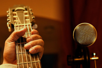 eskua gitarra jotzen eta mikrofonoa