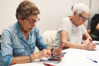 Una mujer consulta su móvil en una sesión del taller