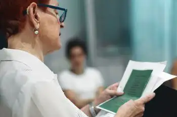 Una mujer mayor leyendo un texto poético en El Rincón de la poesía en Intxaurrondo