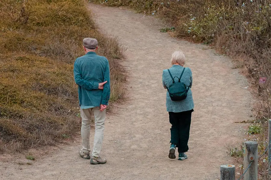 Dos personas mayores paseando por una pista