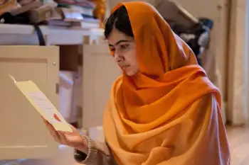 Malala Yousafzai lee vestida con un velo naranja
