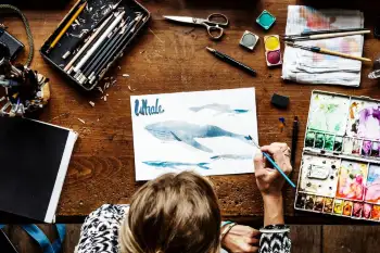 una persona dibujando una ballena sobre un papel