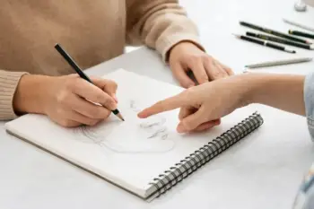 una persona dibujando un rostro sobre un cuaderno