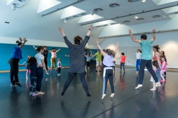 Niñas, niños y adultos saltando y bailando en la sala de danza del Victoria Eugenia