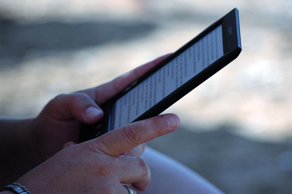 Imagen de una persona leyendo un libro electrónico.
